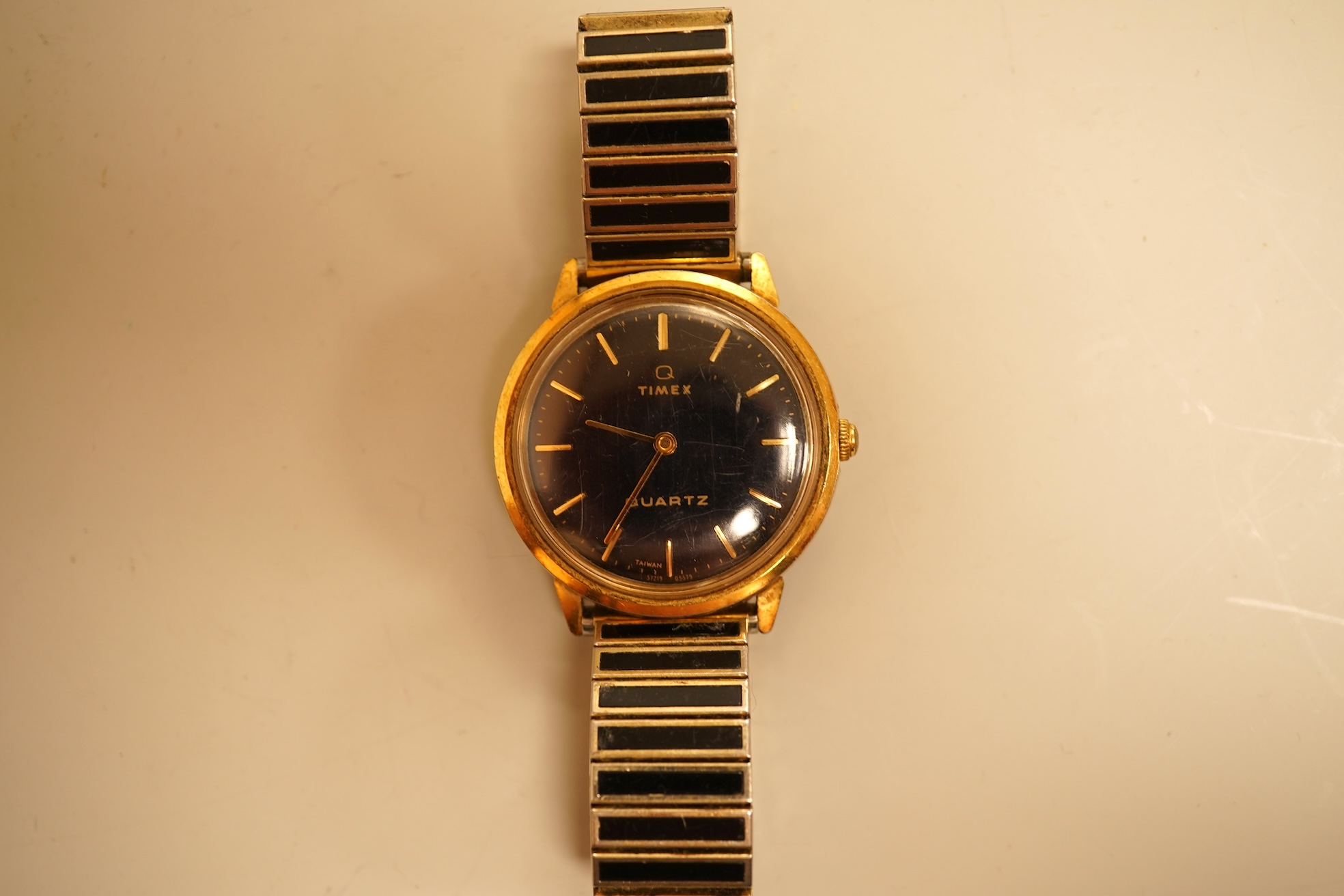 A collection of coins, notes and wrist watches